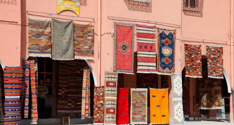 Façade displaying hanging carpets and textiles in a Moroccan medina