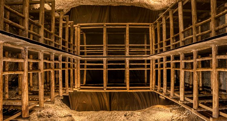 Vista interior de las estructuras de soporte de madera dentro de un complejo de túneles excavados.