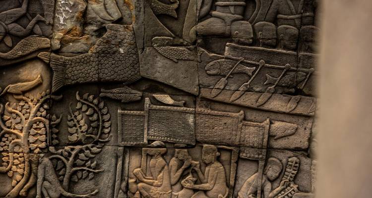 Detailopname van verweerde Angkor steensculpturen die het dagelijks leven en boten uit de oudheid uitbeelden.