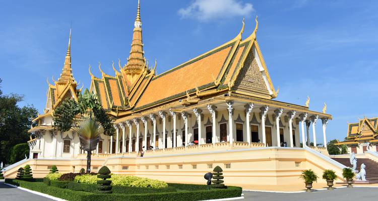 El ornado Salón del Trono con techo dorado del Palacio Real de Phnom Penh brilla contra un cielo azul brillante.