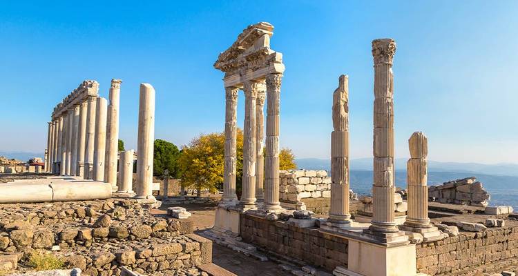 Les colonnes de marbre illuminées par le soleil et les ruines de l'ancienne acropole de Pergame contre un ciel bleu clair.
