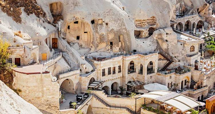 Complexe hôtelier troglodytique creusé dans les falaises tendres de la Cappadoce avec balcons et terrasses.
