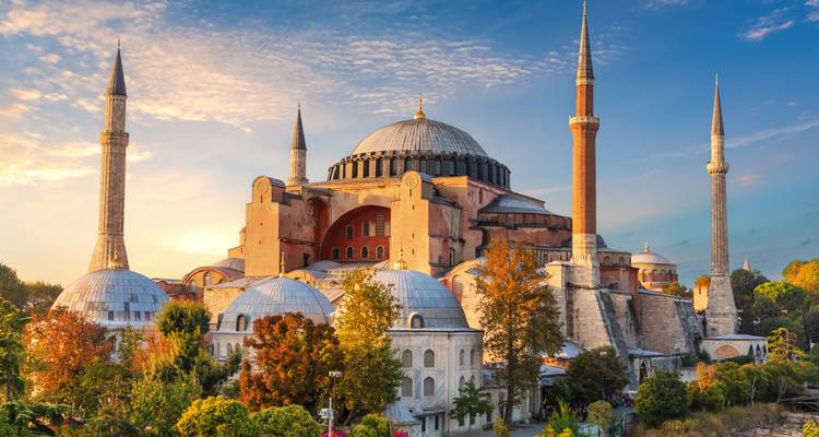 La icónica mezquita-museo de la Basílica de Santa Sofía con sus minaretes iluminados por la cálida luz del atardecer en Estambul.