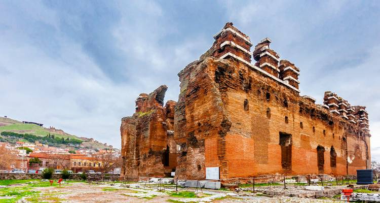 Enormes ruinas de ladrillo rojo de la antigua Basílica Roja en Pérgamo bajo un cielo nublado.