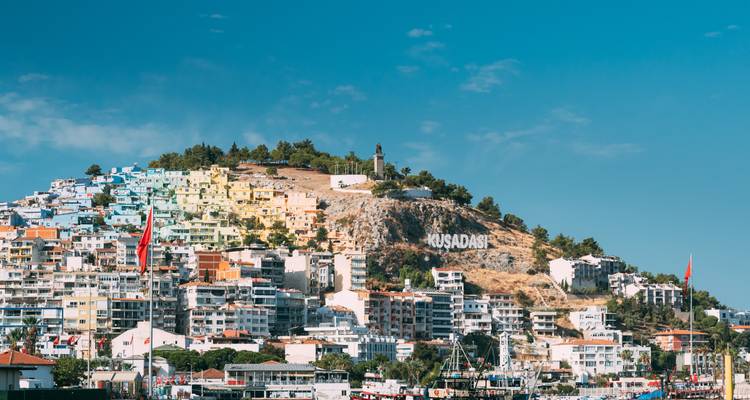 El colorido pueblo de Kusadasi en la ladera con su letrero de nombre visible sobre los edificios del puerto.
