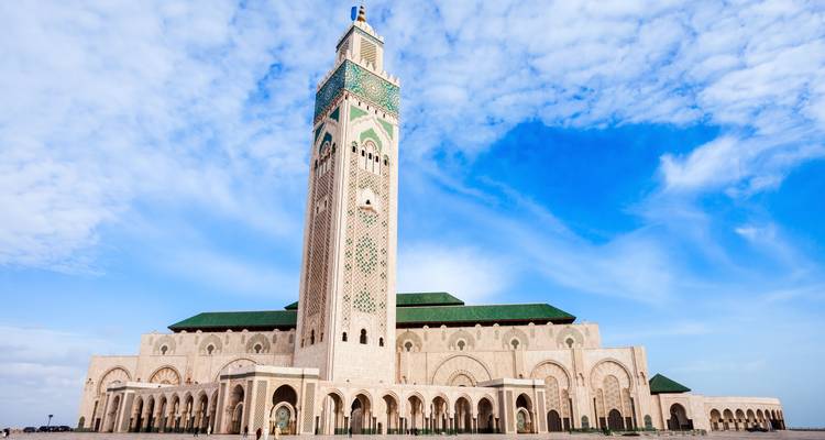 La Gran Mezquita Hassan II con su imponente minarete destacándose contra el cielo azul brillante de Casablanca.