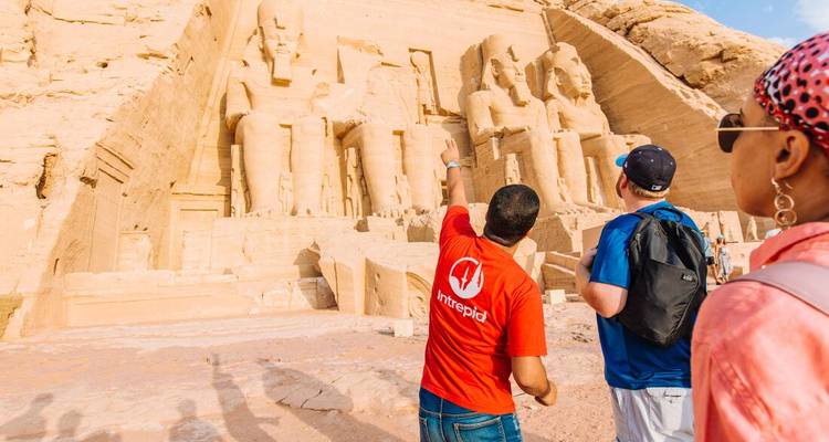 Guide points out colossal statues at Abu Simbel temple to two tourists