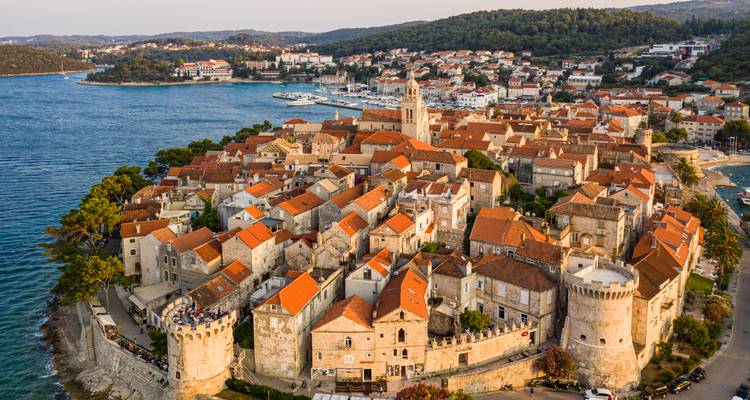 Vue aérienne en heure dorée de la ville médiévale fortifiée de Korčula s'avançant dans la mer Adriatique.
