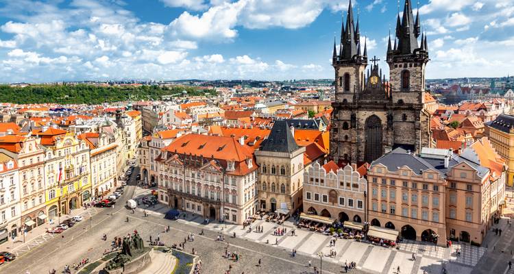 Luftaufnahme des Altstädter Rings in Prag mit der Teynkirche und farbenfrohen Barockgebäuden, die einen lebhaften Platz umgeben.