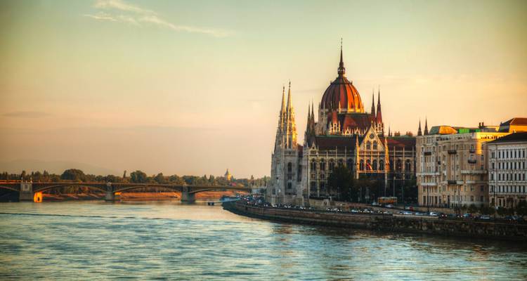 Das Ungarische Parlamentsgebäude im weichen Licht des Sonnenuntergangs neben der Donau in Budapest.