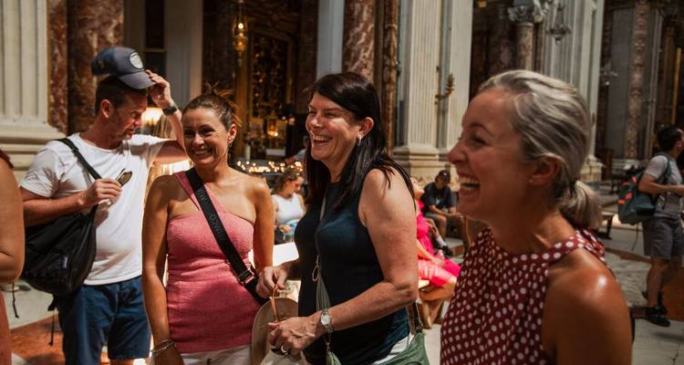 Les voyageurs partagent un rire à l'intérieur d'une église italienne ornée aux colonnes de marbre et aux détails dorés.
