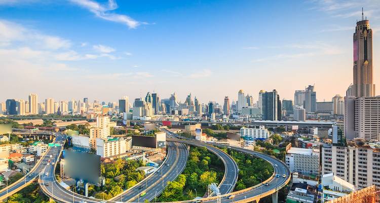 Vue panoramique de la ligne d'horizon de Bangkok avec une autoroute surélevée qui serpente à travers des immeubles modernes de grande hauteur sous un ciel dégagé