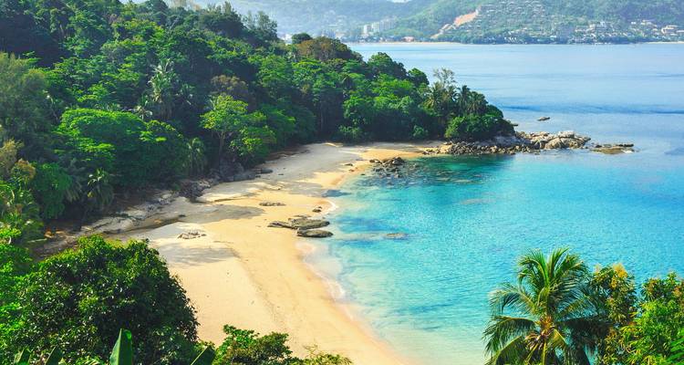 Playa tropical aislada con arena dorada, agua turquesa y cabo cubierto de selva