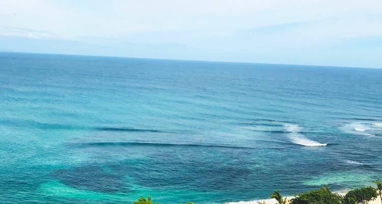 Large étendue d'océan turquoise avec de douces vagues vue depuis une falaise élevée
