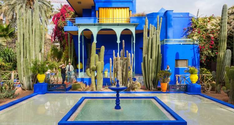 Levendige blauwe villa en cactustuin van Jardin Majorelle weerspiegeld in ondiep zwembad