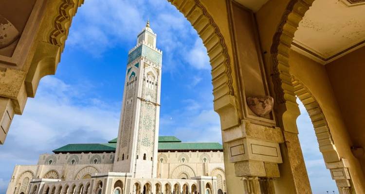 Hassan II-moskee omringd door sierlijke bogen tegen een stralend blauwe lucht in Casablanca