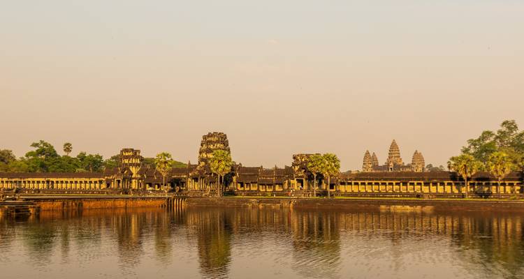 Angkor Wat spiegelt sich in stillen Gewässern während eines goldenen Sonnenaufgangs.