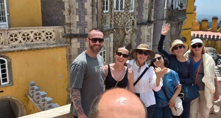 Selfie de groupe devant les murs jaune vif et la facade carrelee du Palais de Pena