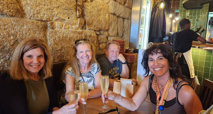 Quatre amis levant des verres de champagne dans un restaurant confortable aux murs en pierre