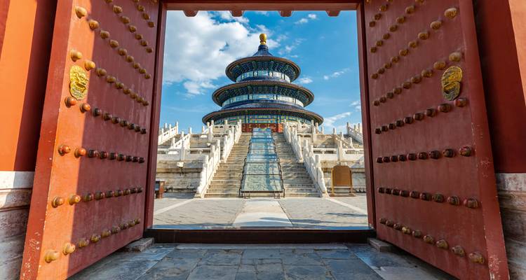 Umrahmt von prunkvollen roten Toren erhebt sich der Himmelstempel majestätisch unter einem strahlend blauen Himmel in Peking.