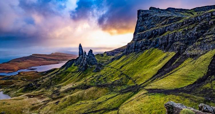 Ein spektakulärer Sonnenaufgang wirft farbiges Licht auf die zerklüfteten Felsspitzen des Old Man of Storr und die umliegende Küste auf der Insel Skye.
