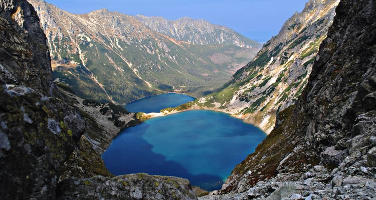 Lagos alpinos azul profundo vistos desde acantilados altos dentro de un anfiteatro montañoso escarpado.