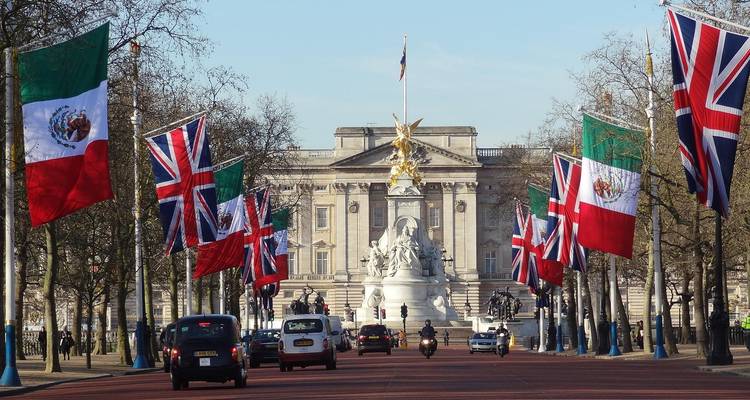Le Palais de Buckingham vu le long de The Mall orné de plusieurs drapeaux nationaux.