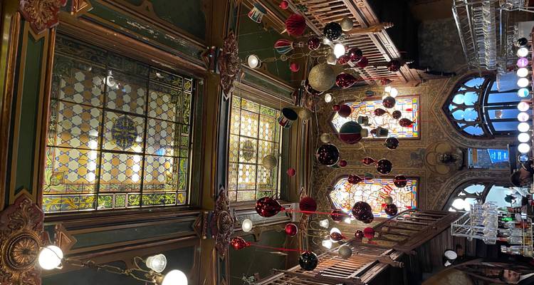 Decoratief glas-in-lood plafond en feestelijke decoraties die hangen in een historische bierhall