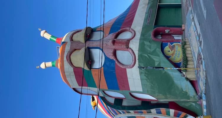 Edificio multicolor y caprichoso con forma de caracol que tiene ojos expresivos y antenas.