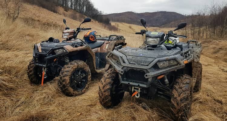 Paar robuster Geländefahrzeuge bereit für ein Offroad-Abenteuer in trockener Graslandschaft.