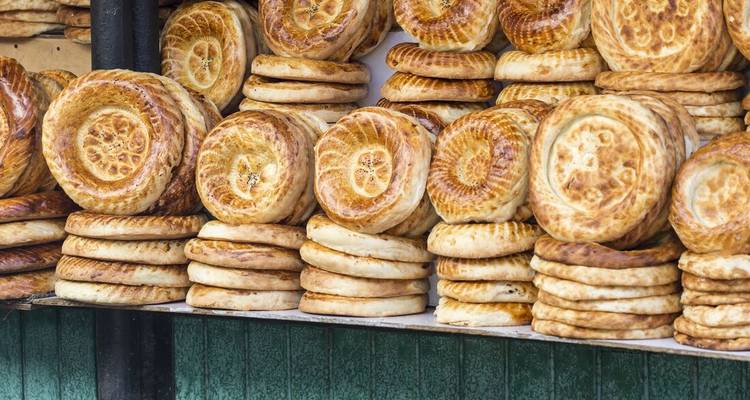 Rijen ronde tandoori-broden met decoratieve patronen gestapeld op een bazaar-kraam.