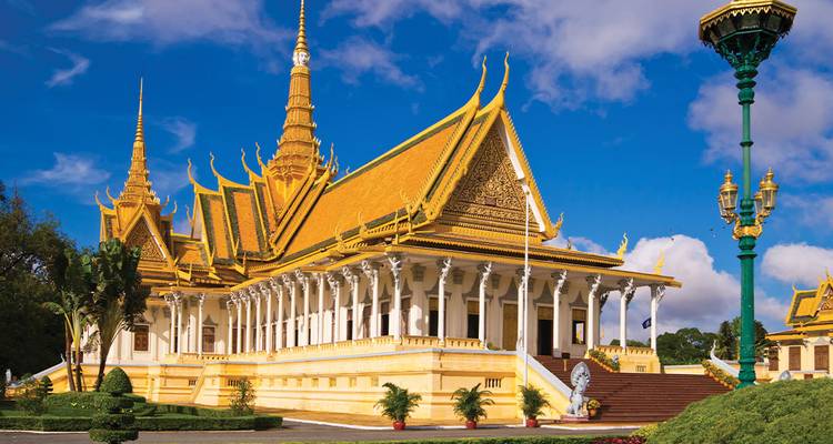 Les flèches dorées et les colonnades blanches du Palais Royal de Phnom Penh brillent contre un ciel bleu éclatant.
