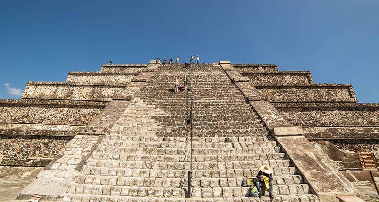 Steep stone staircase of Teotihuacan pyramid with visitors climbing toward the summit