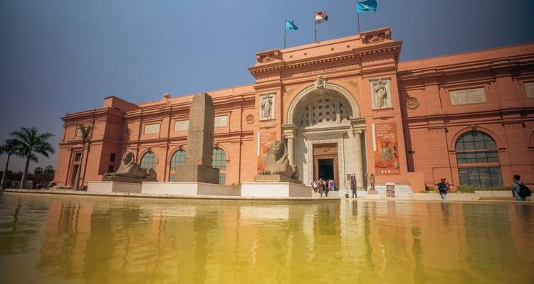 Wide view of the historic Egyptian Museum with reflection in a shallow pool.