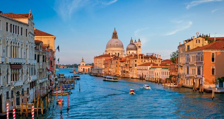 Vista clásica del Gran Canal de Venecia hacia la Basílica de Santa María della Salute con la cálida luz del atardecer.