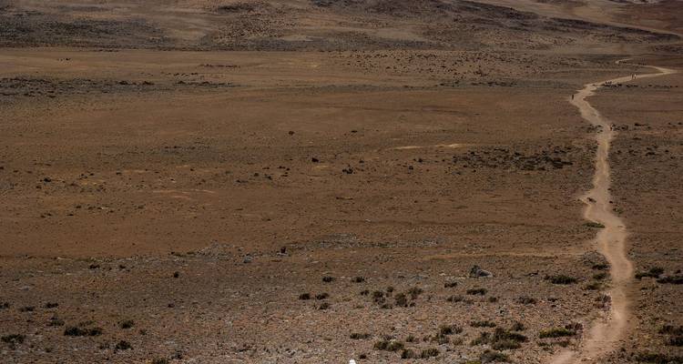 Long dusty trail winding across a barren alpine plateau on Kilimanjaro.
