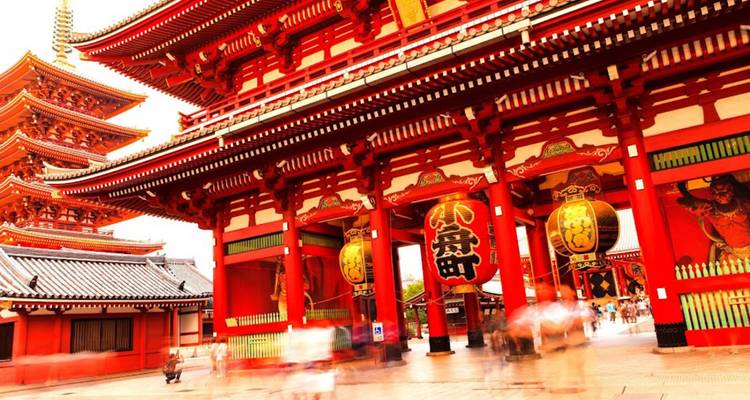 Puerta roja vibrante y pagoda del Templo Senso-ji con visitantes difuminados creando movimiento en la entrada.