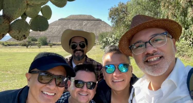 Fünf Freunde machen ein fröhliches Selfie mit der Pyramide der Sonne im Hintergrund.