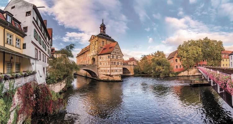 Vue alternative de la pittoresque Mairie ancienne de Bamberg surplombant la voie navigable sous un ciel coloré.