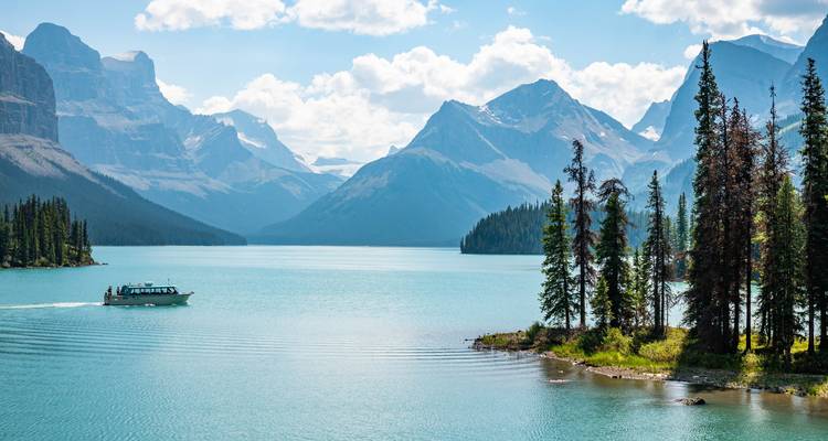 Bootsfahrt auf dem türkisfarbenen Maligne Lake, umgeben von dramatischen Gipfeln der Rocky Mountains.