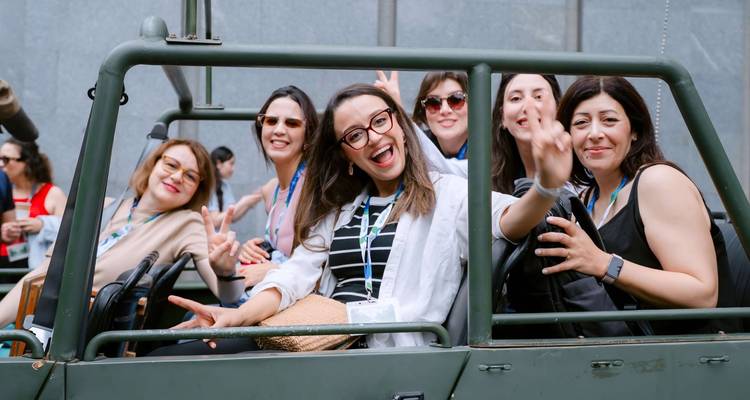 Groupe de femmes joyeuses posant dans une jeep découverte et faisant des signes de paix au Vietnam.