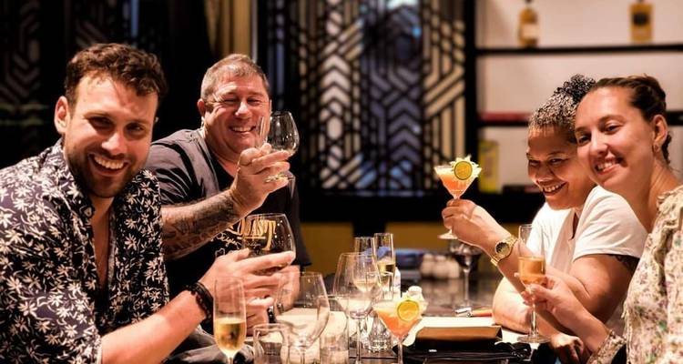 Des amis trinquant avec des verres de vin et de cocktails dans un restaurant vietnamien élégant.