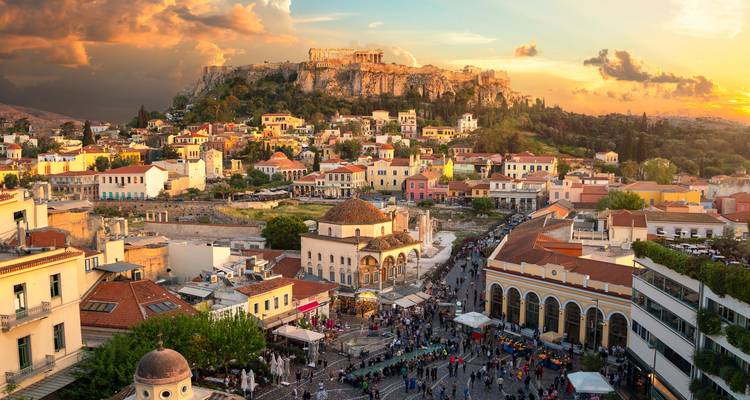 Puesta de sol dorada sobre Atenas con la Acrópolis dominando el horizonte sobre el animado Monastiraki