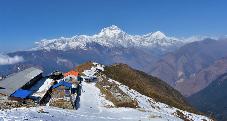 Les lodges isolés sont perchés le long d'une crête enneigée sous la massive chaîne de l'Annapurna.