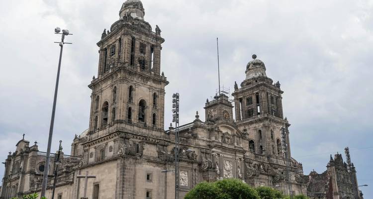 Steintürme der Kathedrale Metropolitana von Mexiko-Stadt erheben sich gegen einen bewölkten Himmel.