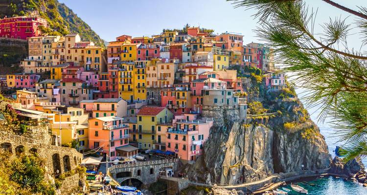 Pueblo vibrante en acantilados de Manarola con casas multicolores cayendo en cascada hacia el mar.