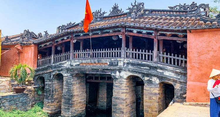Historische Japanse Overdekte Brug in Hoi An met Vietnamese vlag die wappelt.