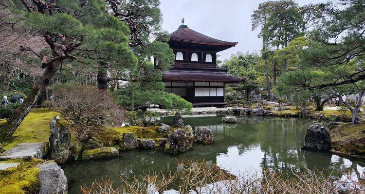 Traditioneel Japans paviljoen weerspiegeld in een rustig vijvertje omringd door een mosguin.