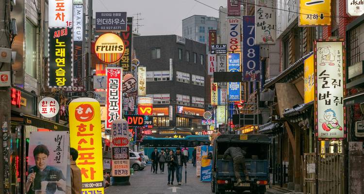 Drukke Koreaanse winkelstraat vol met kleurrijke verticale neonborden.