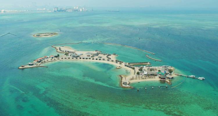 Aerial perspective of small sandy islands ringed by shallow turquoise waters in the gulf.